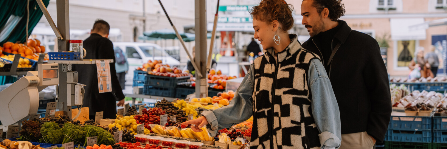 Two people looking at fresh produce at the Grünmarkt (a market in Salzburg) | © TSG Tourismus Salzburg GmbH / M. Kohlmayr
