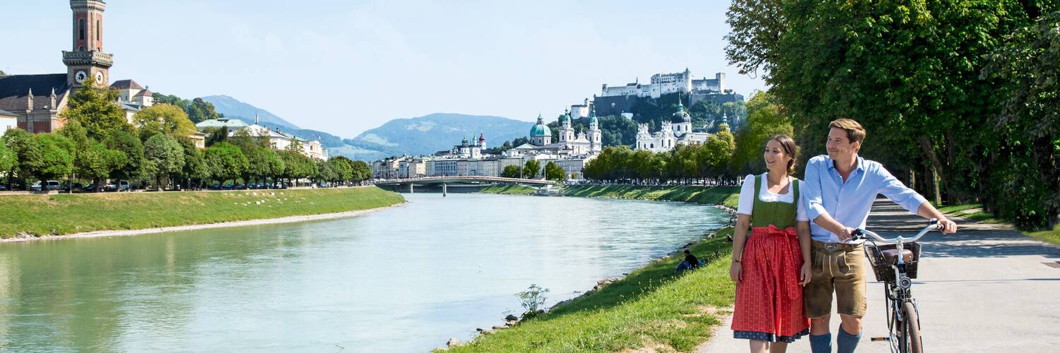 Pärchen mit Rad in Tracht an der Salzach | © Tourismus Salzburg