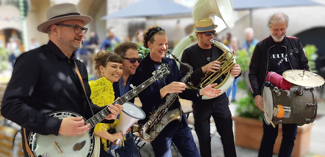 Une scène animée avec un groupe qui se produit. Les musiciens sont ensemble et présentent leur spectacle devant un public. | © MMC