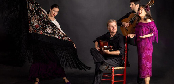 A group of four people is performing a lively music and dance show. Two people are singing, while one plays the guitar and another dances with a scarf. | © Ernest Stierschneider