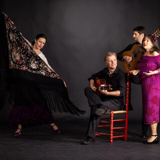 A group of four people is performing a lively music and dance show. Two people are singing, while one plays the guitar and another dances with a scarf. | © Ernest Stierschneider