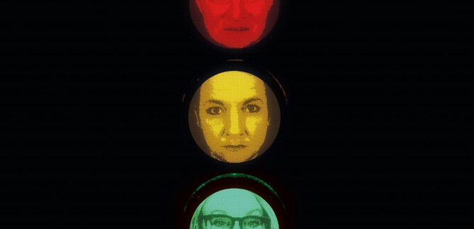 A traffic light that shows faces.  
At the top, a sad face in red, in the middle a neutral face in yellow, and at the bottom a smiling face in green. | © Benjamin Blaikner