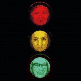 A traffic light that shows faces.  
At the top, a sad face in red, in the middle a neutral face in yellow, and at the bottom a smiling face in green. | © Benjamin Blaikner