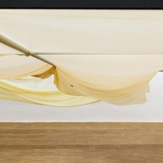 A mermaid sits in the waves of the ocean and looks pensively. Her long, red hair and a flower crown complete the mystical image. | © kunst-dokumentation.com