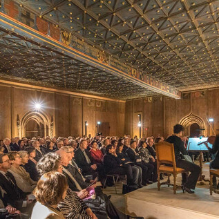 A concert hall with a large audience watching musicians on stage. The atmosphere is festive, and the acoustics are likely excellent. | © Salzburg Highlights