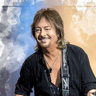 A musician with a guitar is smiling at the camera. The background is artistically designed with colors. | © YEA Sp. z o.o