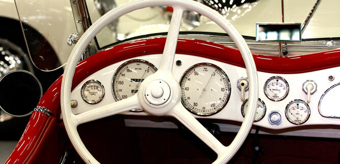 A classic car interior with a white steering wheel and many instruments. The details of the dashboard are elegant and nostalgic. | © Josef Copi / Messezentrum Salzburg