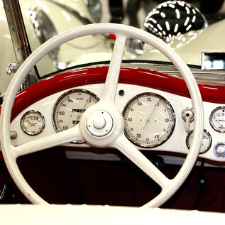 A classic car interior with a white steering wheel and many instruments. The details of the dashboard are elegant and nostalgic. | © Josef Copi / Messezentrum Salzburg