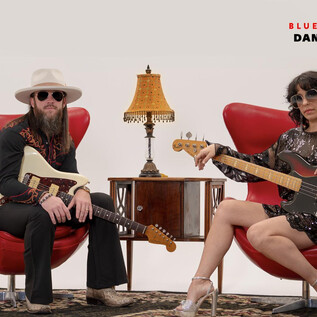 Eine Rockband sitzt in roten Sesseln vor einem minimalistischen Hintergrund. Die Musiker tragen Sonnenbrillen und spielen verschiedene Instrumente. | © Rockhouse Salzburg
