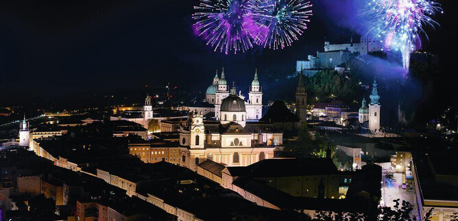 A stunning city view at night with colorful fireworks. In the background, historic buildings and an impressive fortress can be seen. | © SLT / Anna-Maria Löffelberger