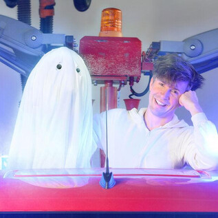 A man is sitting in a vehicle next to a ghostly, white spirit. Blue lights and smoke can be seen in the background. | © SLT / Christian Krautzberger