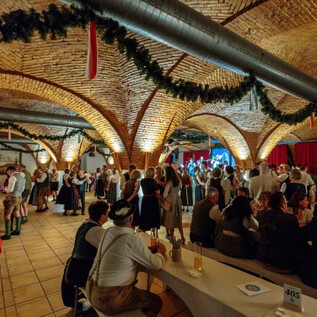 A lively event in a festively decorated room with vaulted ceilings. People in traditional clothing are dancing and celebrating together. | © Edelweiss-Club