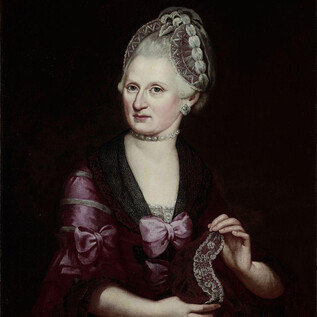 A portrait of an elegant lady in a magnificent dress adorned with purple and black decorations. She holds a lace piece in her hand and has an elaborate hairstyle. | © ISM