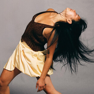 Tanečnice s dlouhými vlasy a šaty. Pohybuje se dynamicky před šedým pozadím. | © Chris Rogl