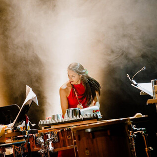 A musician is playing an instrument on stage. In the background, a fog-filled atmosphere can be seen. | © Salzburger Kulturvereinigung