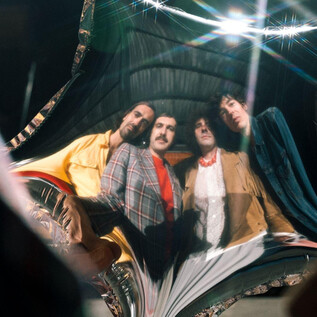 A distorted shot of four men smiling at the camera. The background is distorted and reflects interestingly. | © Ines Futterknecht