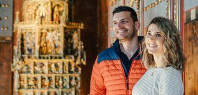 Egy történelmi konyha régi főzőedényekkel és egy kő kandallóval. A padló nagy kövekből készült, és különböző fazekak és kannák találhatók. | © Kathrin Gollackner Fotografie