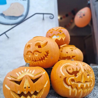 A group of carved pumpkins with various spooky faces. In the background, some Halloween decorations can be seen. | © Salzburger Burgen und Schlösser