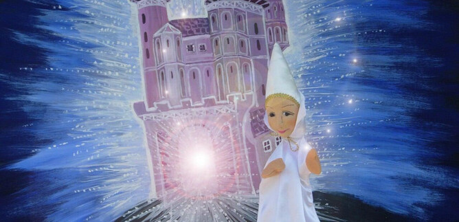 A doll in a white garment stands in front of a glowing castle. The background features a sparkling, dreamlike scene. | © Friedburger Puppenbühne