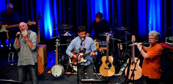 A band is performing on a stage. There are several instruments and the musicians are playing passionately. | © Heinz Bayer