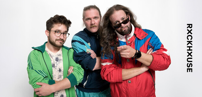 Three men in colorful sports jackets pose together. They have various accessories and facial expressions that convey a casual and confident impression. | © Prenninger