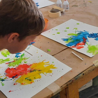 Eine Sammlung von Buntstiften und Scheren in Metallbehältern. Im Vordergrund sind orangefarbene Schalen sichtbar. | © DomQuartier