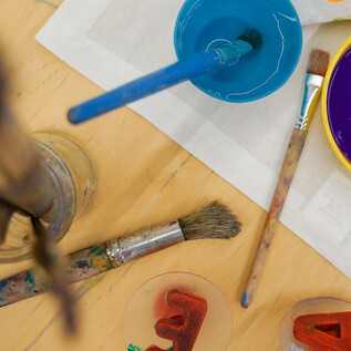 Two pumpkins with Halloween motifs are on a table. One pumpkin is bright and has a happy face, while the other is decorated with tools. | © Khan Eram/Spielzeug Museum