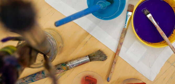 Two pumpkins with Halloween motifs are on a table. One pumpkin is bright and has a happy face, while the other is decorated with tools. | © Khan Eram/Spielzeug Museum