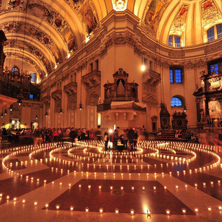 Impozantní kostel s velkým množstvím hořících svíček uspořádaných do spirálovitého vzoru. Vysoký strop a umělecké ozdoby vytvářejí slavnostní atmosféru. | © eds WEB