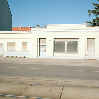 Three traffic signs stand in a snowy landscape. The atmosphere is gray and foggy, with a quiet stream in the background. | © Leo Kandl