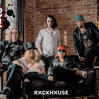 A rock band poses in a stylish room with a brick wall. They are wearing dark clothing and exude an energetic vibe. | © Reckless Roses, Rockhouse Salzburg
