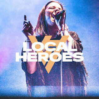 A singer performs on a stage, surrounded by colorful lights. The wording "LOCAL HEROES" is prominently placed in the image. | © Rockhouse Salzburg