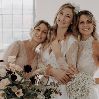 Eine lebendige Bühnenaufführung mit vier Künstlern, die in glitzernden Outfits vor einem großen, herzförmigen Discokugel stehen. Bunte Lichter und eine festliche Atmosphäre sorgen für eine fröhliche Stimmung. | © Austria Wedding