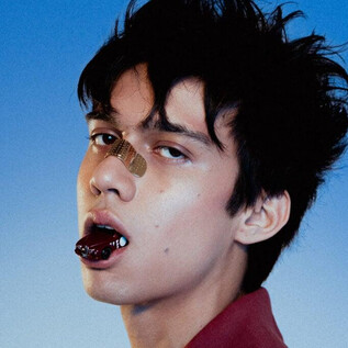A teenager with tousled hair is looking directly at the camera. He has a bandage on his nose and a striking expression on his face. | © Mala Kolumna