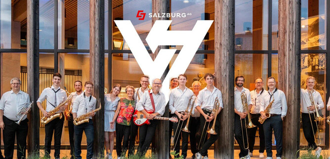A group of musicians stands in front of a modern building with a wooden facade. They are holding various musical instruments and smiling at the camera. | © Rockhouse Salzburg
