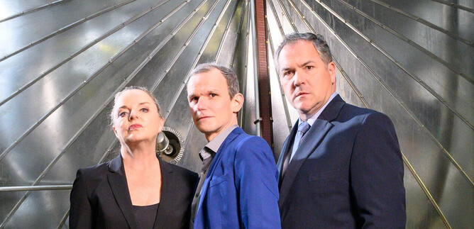 Three people are standing in front of a large, silver structure. The atmosphere is modern and professional. | © SLT / Tobias Witzgall