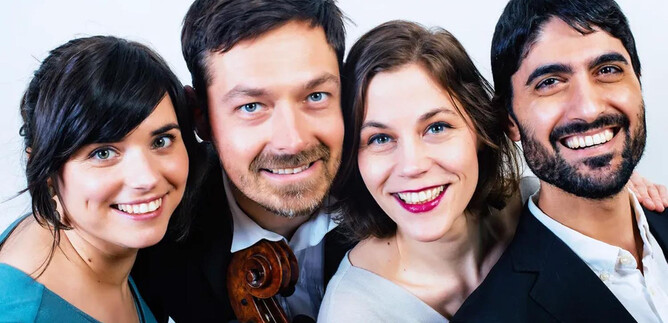 A group of four musicians smiles at the camera. They hold instruments and look friendly. | © Wolfram Knelangen