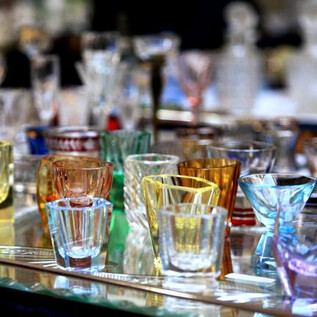Various colorful glasses are placed on a table. The glasses are depicted in different shapes and colors. | © sr.märkte