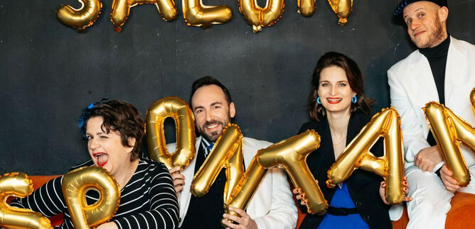 A group of four people is sitting on a couch and holding golden balloon letters. They form the word "SALON SPONTAN" in the background. | © Sarah Baum