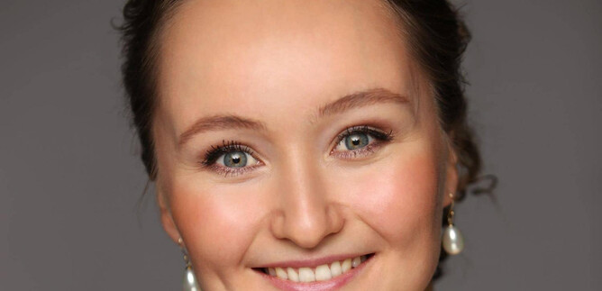 A woman with a friendly smile and bright eyes. She is wearing elegant earrings and has a natural aura. | © Emil Matveev