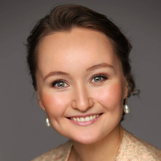 A woman with a friendly smile and bright eyes. She is wearing elegant earrings and has a natural aura. | © Emil Matveev