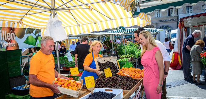 A lively market with fresh fruits and friendly vendors.  
People enjoy the atmosphere and choose from a colorful selection of products. | © Tourismus Salzburg GmbH, Breitegger G.