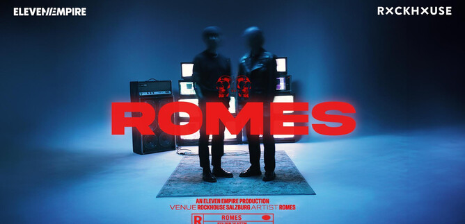 Two silhouette-like figures stand in front of several screens in a blue room. The text "ROMES" is highlighted in red. | © Rockhouse Salzburg
