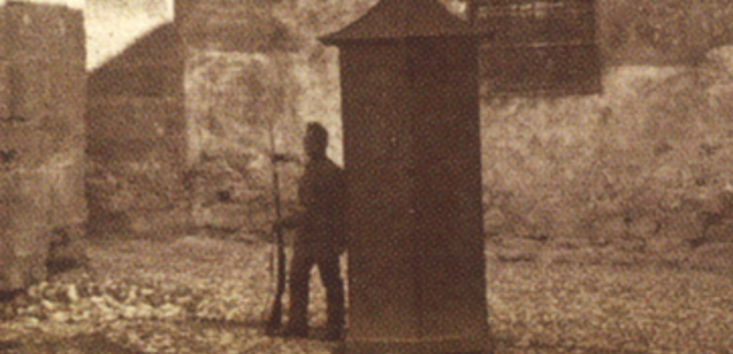 Egy történelmi konyha régi főzőedényekkel és egy kő kandallóval. A padló nagy kövekből készült, és különböző fazekak és kannák találhatók. | © Festung Hohensalzburg