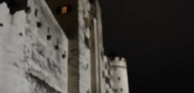 A creepy carved pumpkin glows in front of an old castle at night. The atmosphere is mysterious and fitting for Halloween. | © Salzburger Burgen und Schlösser