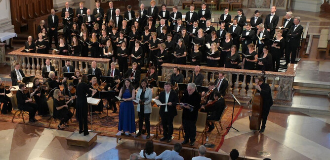 A choir sings in a church, surrounded by musicians. The atmosphere is festive and musical. | © Dom zu Salzburg