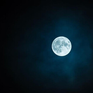 A clear full moon shines in the night sky. Surrounded by dark clouds, it radiates a soothing brightness. | © Salzburger Freilichtmuseum