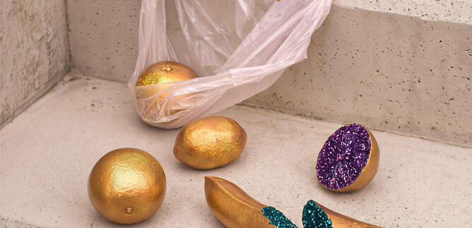 Eine ungewöhnliche Ansicht von Goldkugeln und einer bunten Banane, die auf einer Treppe verteilt sind. Eine durchsichtige Plastiktüte liegt ebenfalls auf den Stufen. | ©  Schauspielhaus Salzburg