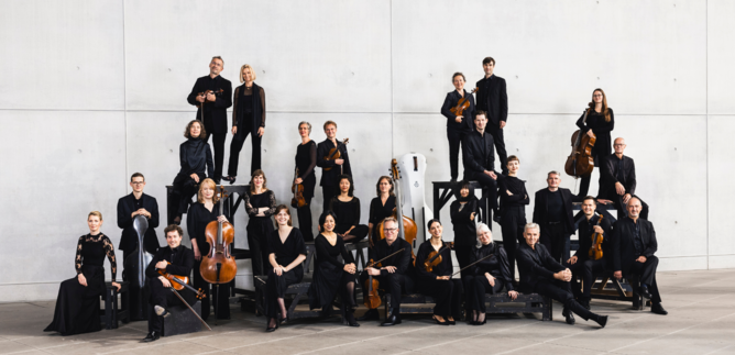 A group of musicians is playing together on a stage. The room has high windows and an acoustically pleasant atmosphere. | © Daniel-Delang