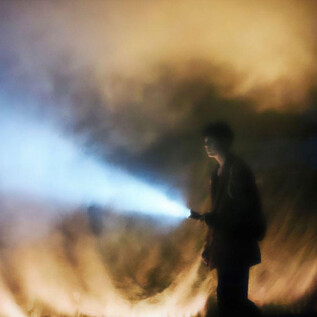 A person stands in a foggy environment holding a flashlight. The light from the flashlight breaks through the fog and creates a mysterious atmosphere. | © Benjamin Blaikner